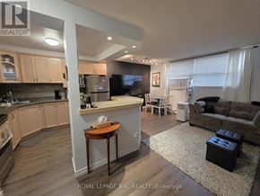 St. Catharines (Oakdale) condo for rent - A well-lit kitchen and living room with a couch and a coffee table.