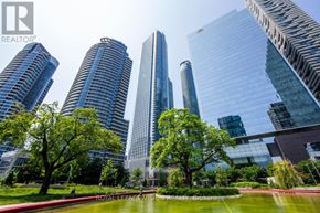 Toronto (Waterfront Communities) condo for rent - A cityscape with skyscrapers and a pond in the foreground.