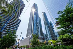 Toronto (Waterfront Communities) condo for rent - A cityscape with skyscrapers and trees in the foreground.