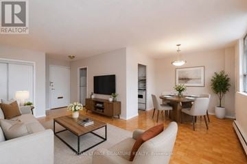 Toronto (Mount Pleasant East) condo for rent - A living room with a white couch, a coffee table, and a television.