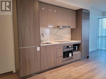 Vaughan (Vaughan Corporate Centre) condo for rent - A modern kitchen with wooden cabinets and a marble countertop.
