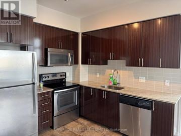 Vaughan (Beverley Glen) condo for rent - A kitchen with dark brown cabinets and stainless steel appliances.