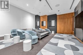 Oakville (Go Glenorchy) condo for rent - A modern living room with a grey carpet and a wooden door.