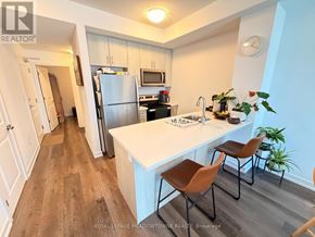 Hamilton (Waterdown) condo for rent - A kitchen with a white countertop and brown chairs.