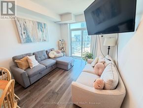 Hamilton (Waterdown) condo for rent - A living room with a grey couch and a television.