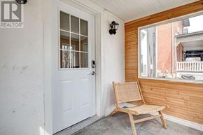 Guelph (Downtown) duplex for rent - A white door with a glass window is on the left and a wooden chair is on the right.