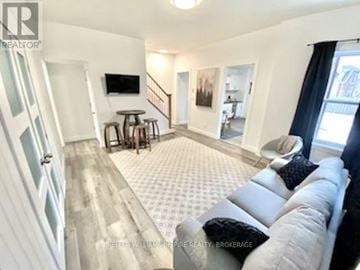 Belleville (Belleville Ward) apartment for rent - A living room with a grey couch and a television on the wall.