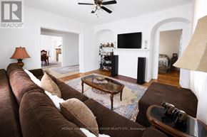 Barrie (City Centre) apartment for rent - A living room with a brown couch and a flat screen TV mounted on the wall.