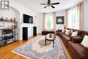 Barrie (City Centre) apartment for rent - A living room with a brown couch, a rug, and a fireplace.