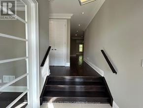 Oakville (Go Glenorchy) apartment for rent - A hallway with a staircase leading to a door at the end.