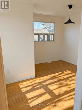 Hamilton (Eastmount) multi-family for rent - A room with a window and a hanging light fixture.