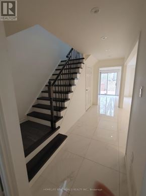 Markham (Raymerville) apartment for rent - A staircase with black and white steps leads to a bright room with a window.