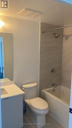 Burlington (Brant) condo for rent - A white toilet sits next to a sink in a small bathroom.