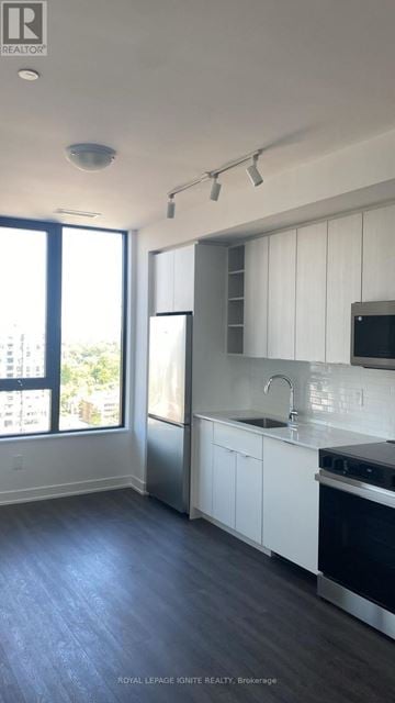 Burlington (Brant) condo for rent - A kitchen with white cabinets and a black stove top oven.