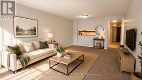 Toronto (Bay Street Corridor) condo for rent - A living room with a white sofa, a coffee table, and a painting on the wall.