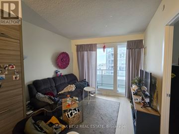 Toronto (Mount Pleasant West) condo for rent - A living room with a black couch and a TV on the right side.