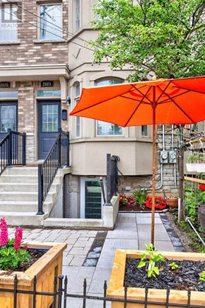 Toronto (O'connor-Parkview) townhouse for rent - A bright orange umbrella is in front of a building with a black gate.