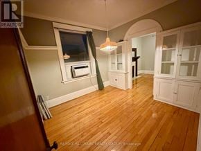 Ottawa triplex for rent - A room with wooden floors and white cabinetry is shown.