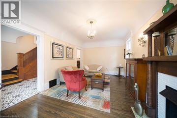 Brantford apartment for rent - A living room with a red chair and a fireplace.