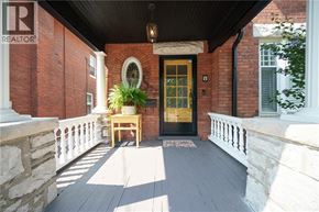 Brantford apartment for rent - A balcony with a table and chairs and a door.