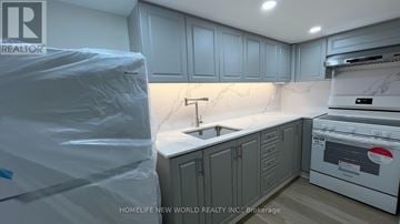 Aurora apartment for rent - A kitchen with a white countertop and grey cabinets is shown.