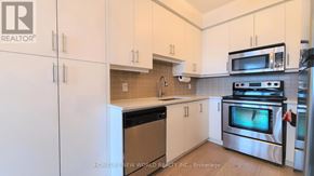 Mississauga (Port Credit) condo for rent - A kitchen with white cabinets and stainless steel appliances.