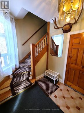 Toronto (Runnymede-Bloor West Village) duplex for rent - A hallway with a checkered floor and a chandelier.