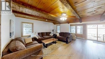 Ramara apartment for rent - A living room with a brown couch and a wooden ceiling.