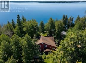 Ramara apartment for rent - A house surrounded by trees with a body of water in the background.