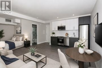 Toronto (Annex) condo for rent - A modern living room with a dining area and kitchen in the background.
