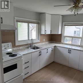 Halton Hills (Rural Halton Hills) apartment for rent - A kitchen with white cabinets and a stove top oven.
