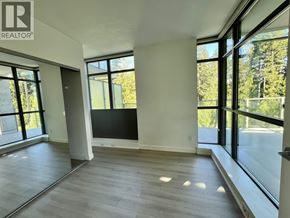 Vancouver apartment for rent - A spacious room with large windows and a wooden floor.
