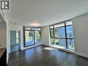 Vancouver apartment for rent - A spacious room with wooden floors and large windows.