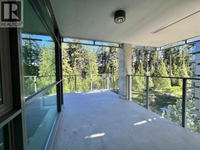 Vancouver apartment for rent - A balcony with a glass railing and a view of trees.