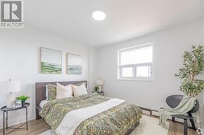 Hamilton (Rosedale) condo for rent - A bedroom with a bed, a chair, and a plant.