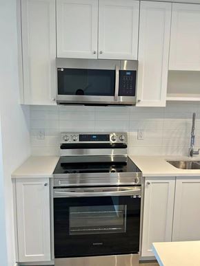 Surrey townhouse for rent - A modern kitchen with a stove, oven, and microwave.