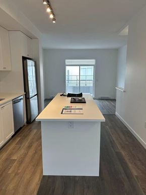 Surrey townhouse for rent - A white kitchen island with a book and a remote control on it.