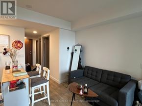 Toronto (Waterfront Communities) condo for rent - A living room with a black couch and a wooden table.