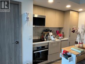 Toronto (Waterfront Communities) condo for rent - A kitchen with a wooden door and a counter with a blender on it.