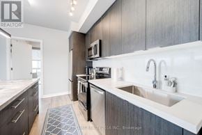 Toronto (Waterfront Communities) condo for rent - A modern kitchen with dark wood cabinets and white countertops.