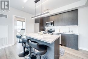 Toronto (Waterfront Communities) condo for rent - A modern kitchen with a bar area and a dining area.