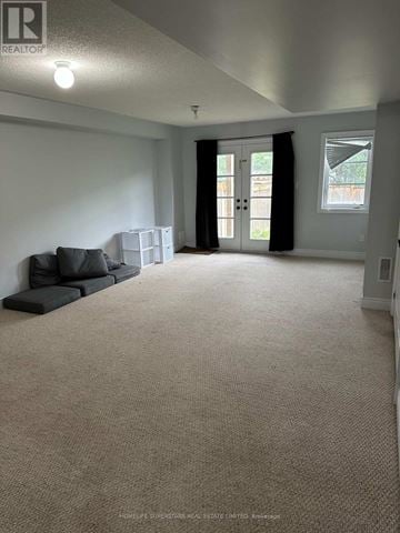 Richmond Hill (Oak Ridges) townhouse for rent - A spacious living room with a grey sofa and a carpeted floor.