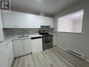Ottawa townhouse for rent - A kitchen with white cabinets and a black stove top oven.