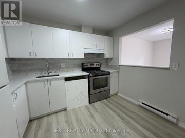 Ottawa townhouse for rent - A kitchen with white cabinets and a black stove top oven.