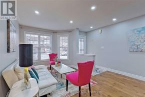 Brampton (Fletcher's Meadow) apartment for rent - A living room with a white couch, a pink chair, and a painting on the wall.