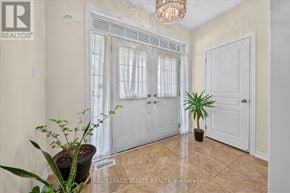 Brampton (Credit Valley) apartment for rent - A room with a plant, a door, and a chandelier.