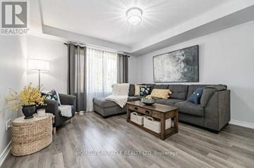 Kitchener townhouse for rent - A living room with a grey couch, a coffee table, and a painting on the wall.