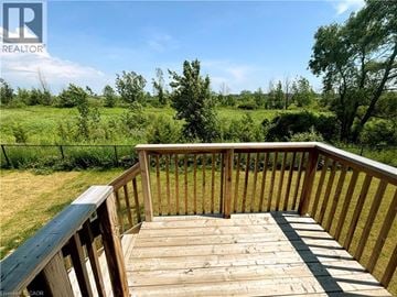 Welland apartment for rent - A wooden deck overlooks a grassy field.