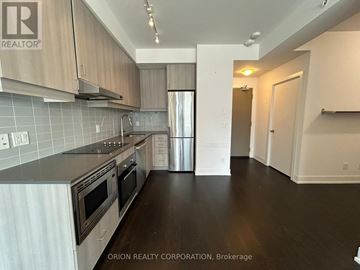 Toronto (Bayview Village) condo for rent - A kitchen with a stove top oven and a refrigerator.
