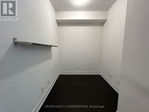 Toronto (Bayview Village) condo for rent - A room with a black floor and a white wall with a brokerage sign.